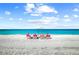 Beach scene with people relaxing under an umbrella at 443 Picasso Dr, Nokomis, FL 34275