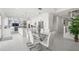 Modern dining area with glass table and white chairs, open to kitchen at 443 Picasso Dr, Nokomis, FL 34275