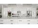 Modern kitchen with white cabinets, large island, and stainless steel appliances at 443 Picasso Dr, Nokomis, FL 34275