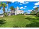 Lush lawn with mature palm trees and house view at 443 Picasso Dr, Nokomis, FL 34275