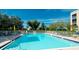 Community pool surrounded by lounge chairs, umbrellas, and greenery in a well-maintained recreation area at 4410 Fairways Blvd # 505, Bradenton, FL 34209