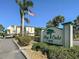 Bay Oaks community sign featuring lush landscaping, palm trees, and a view of the building at 6157 Midnight Pass Rd # C11, Sarasota, FL 34242