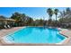 Community pool with clear blue water, surrounded by a brick patio and lounge chairs at 8922 White Sage Loop # 3001, Lakewood Ranch, FL 34202