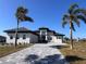 Two-story home with a three-car garage and palm trees at 5061 Collingswood Blvd, Port Charlotte, FL 33948