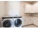 Well-lit laundry room with washer, dryer, and cabinets at 5061 Collingswood Blvd, Port Charlotte, FL 33948