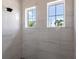 Walk-in shower with marble tile and two windows offering natural light at 5061 Collingswood Blvd, Port Charlotte, FL 33948