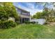 Grassy backyard with mature trees and a white privacy wall at 445 Palm Tree Dr, Bradenton, FL 34210