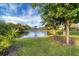 Scenic pond view with a fountain, surrounded by lush landscaping and mature trees at 445 Palm Tree Dr, Bradenton, FL 34210