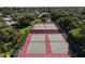 Aerial view of four well-maintained tennis courts surrounded by lush greenery at 445 Palm Tree Dr, Bradenton, FL 34210