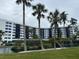 Curved waterfront building with palm trees and landscaping at 5855 Midnight Pass Rd # 416, Sarasota, FL 34242