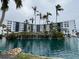 Exterior view of condo building with a pond and palm trees at 5855 Midnight Pass Rd # 416, Sarasota, FL 34242