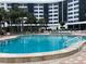 Community pool with surrounding lounge chairs and building view at 5855 Midnight Pass Rd # 416, Sarasota, FL 34242
