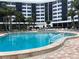 Community pool with surrounding lounge chairs and building view at 5855 Midnight Pass Rd # 416, Sarasota, FL 34242
