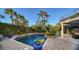 Inviting pool area with brick pavers, lush landscaping, and a water feature at 6934 Belgrave Dr, Siesta Key, FL 34242