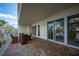 Spacious balcony with brick pavers and wicker furniture, offering water views at 1660 Summerhouse Ln # 102, Sarasota, FL 34242