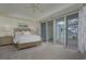Bright bedroom with sliding doors to balcony and water views at 1660 Summerhouse Ln # 102, Sarasota, FL 34242