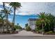 Gated community entrance with palm trees and paved driveway at 1660 Summerhouse Ln # 102, Sarasota, FL 34242