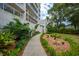 A paved walkway winds through lush landscaping towards the building entrance at 1660 Summerhouse Ln # 102, Sarasota, FL 34242