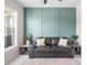 Living room featuring a leather couch and a teal accent wall at 11926 Seabrook Ave, Lakewood Ranch, FL 34211