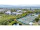 Overhead view showcases condos, verdant trees, tennis courts, a pond, and manicured foliage at 815 Bayport Way # 815, Longboat Key, FL 34228