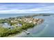 Aerial view of coastal neighborhood featuring waterfront homes and a pier stretching into the serene water at 815 Bayport Way # 815, Longboat Key, FL 34228