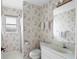 Clean bathroom with floral wallpaper and shower at 1654 Waxwing Ct, Venice, FL 34293