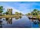 Peaceful canal view with sailboat and lush tropical landscaping at 4409 Crews Ct, Port Charlotte, FL 33952