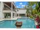 Expansive backyard with a large swimming pool, patio, and meticulous landscaping at 5005 Gulf Of Mexico Dr # 5, Longboat Key, FL 34228