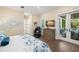 Comfortable bedroom with hardwood floors, decorative wall art, massage chair, and access to a private balcony at 5005 Gulf Of Mexico Dr # 5, Longboat Key, FL 34228