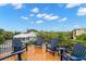 Inviting outdoor deck features blue chairs with expansive views of lush surroundings and water at 5005 Gulf Of Mexico Dr # 5, Longboat Key, FL 34228