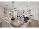 Bright kitchen featuring a wooden dining table, white cabinets, stainless steel appliances, and decorative shelving at 5005 Gulf Of Mexico Dr # 5, Longboat Key, FL 34228