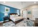 Bright main bedroom featuring a blue accent wall, wood floors, and stylish decor at 5005 Gulf Of Mexico Dr # 5, Longboat Key, FL 34228