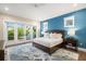 Bright main bedroom featuring a blue accent wall, wood floors, and access to an outdoor balcony at 5005 Gulf Of Mexico Dr # 5, Longboat Key, FL 34228