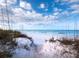 Steps to pristine beach with white sand and dunes at 542 Sutton Pl, Longboat Key, FL 34228