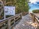 Wooden boardwalk leading to the beach, with educational signage at 542 Sutton Pl, Longboat Key, FL 34228