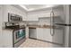 Well-equipped kitchen featuring stainless steel appliances and white cabinetry at 542 Sutton Pl, Longboat Key, FL 34228