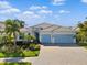 Beautiful two-story house with light blue garage doors and a landscaped front yard at 7749 Sandhill Lake Dr, Sarasota, FL 34241