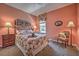 Well-lit bedroom with a floral bedspread and a comfortable chair at 8047 Victoria Falls Cir, Sarasota, FL 34243