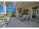 Spacious covered patio with wicker furniture, ceiling fan, and lush greenery at 8047 Victoria Falls Cir, Sarasota, FL 34243