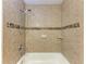 The bathroom features a shower over the tub, with beige and brown tiling at 3411 Clark Rd # 212, Sarasota, FL 34231