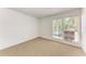 Bright bedroom featuring neutral carpet, white walls, and a window with blinds at 3411 Clark Rd # 212, Sarasota, FL 34231