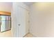Hallway with a storage closet that leads to the kitchen, featuring a stainless-steel refrigerator at 3411 Clark Rd # 212, Sarasota, FL 34231