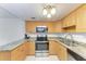 Kitchen with stainless steel appliances, granite countertops, wood cabinetry, and tile floors at 3411 Clark Rd # 212, Sarasota, FL 34231