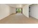 Spacious carpeted living room with balcony access, with a view of the washer and dryer at 3411 Clark Rd # 212, Sarasota, FL 34231