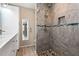 Updated bathroom with walk-in shower, stone tile, and pebble floor at 4629 Whirlaway Dr # B, Sarasota, FL 34233