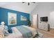 Virtually staged bedroom with blue accent wall and white bedding at 4629 Whirlaway Dr # B, Sarasota, FL 34233