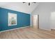 Spacious bedroom with blue accent wall and wood-look floors at 4629 Whirlaway Dr # B, Sarasota, FL 34233