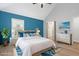 Virtually staged bedroom with blue accent wall and wood-look floors at 4629 Whirlaway Dr # B, Sarasota, FL 34233