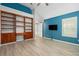 Bedroom with built-in shelves, wood-look floors, and blue walls at 4629 Whirlaway Dr # B, Sarasota, FL 34233