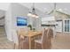 Virtually staged dining room with light wood table and chairs, adjacent to the kitchen at 4629 Whirlaway Dr # B, Sarasota, FL 34233